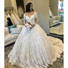 a woman in a wedding dress standing on a carpeted floor next to a couch