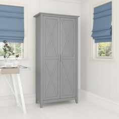 a gray cabinet sitting in the corner of a room next to a window with blue roller shades