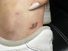 a woman's foot with a small tattoo on the left side of her ankle