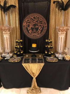 a table topped with black and gold decorations