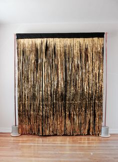 a curtain with gold tinsel hanging from it's side in an empty room