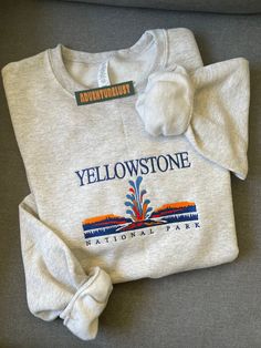 - Yellowstone National Park Embroidered Crewneck - Perfect gift for nature lovers, adventurers, or anyone who loves National Parks.  - Fabrication - Heathered grey color crewneck - 70/20 cotton/poly blend - Size is unisex - Care Instructions - Turn inside out and machine wash cold on delicate cycle - Dry on low heat setting - Do not bleach or dry clean - Processing and Shipping Times - Please allow 3-5 business days for your order to be processed and stitched - Standard shipping takes 3-5 days - State Embroidery, Shirt Outfit Ideas, Wyoming State, Fashion Layout, Trendy Hoodies, Embroidery Sweatshirt, Kinds Of Clothes, Fall Sweatshirt, Cozy Outfit