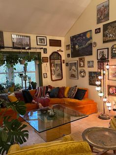 a living room filled with lots of furniture and pictures on the wall above it's glass top coffee table