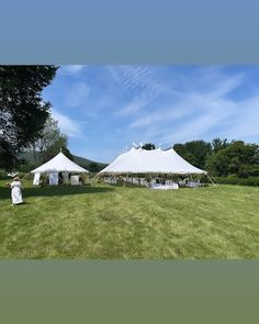 a large white tent set up in the middle of a field