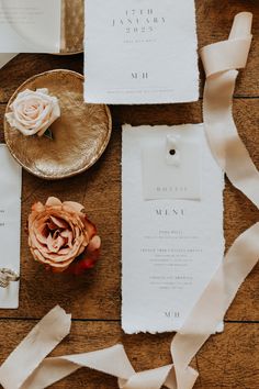 the wedding stationery is laid out on top of each other with ribbons and flowers