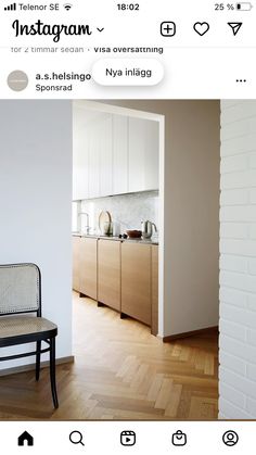 a chair sitting on top of a hard wood floor next to a white kitchen wall