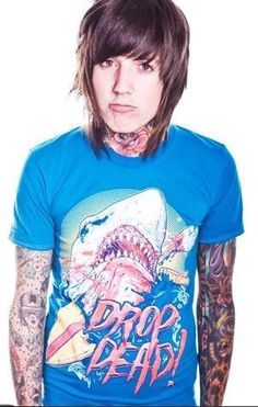 a man with tattoos on his arms and chest wearing a blue t - shirt that says drop dead