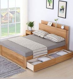 a bed with two drawers underneath it in a room next to a rug and window