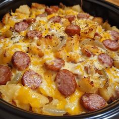 a close up of a casserole dish in a crock pot with sausage and potatoes