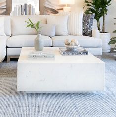 a living room filled with furniture and a white coffee table in front of a couch