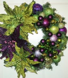 a christmas wreath with purple and green ornaments