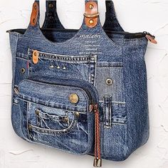 a purse made out of jeans hanging on a wall with two zippers attached to it