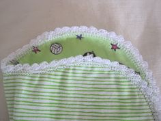 a green and white striped diaper cover with crochet lace on the bottom