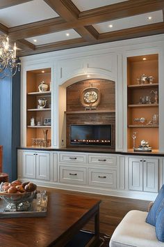 a living room filled with furniture and a fire place in the middle of it's wall