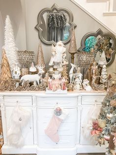 a white dresser topped with lots of christmas decorations