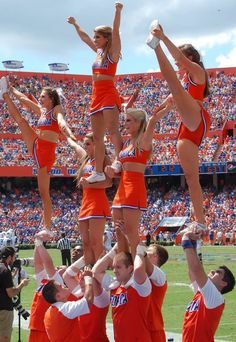 the cheerleaders are doing tricks in front of an audience at a football game