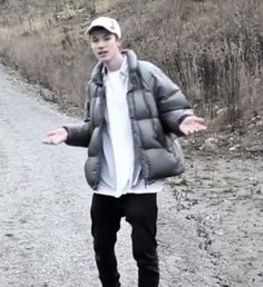 a young man riding a skateboard down a dirt road