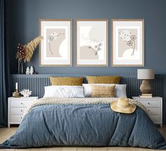 a bedroom with blue walls and two pictures on the wall above the bed, along with a straw hat