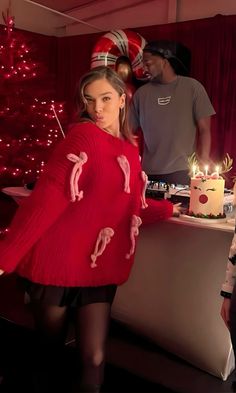 a woman standing in front of a cake with candles on it