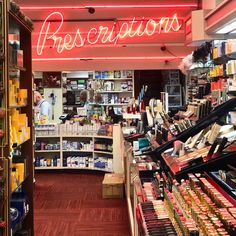 the inside of a cosmetics store with red neon signs above it and shelves full of beauty products