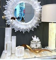 a table with a mirror, vases and other items sitting on top of it