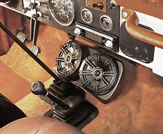 the interior of an old fashioned car with leather seats and dashboards, including steering wheel