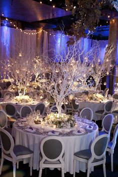 the tables are set with white tablecloths and centerpieces for an elegant event