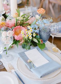 the table is set with flowers and place settings