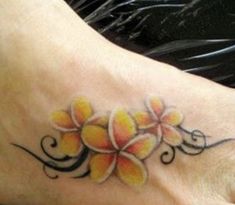 a tattoo on the foot of a woman with yellow flowers and swirls around it