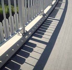 a long white fence on the side of a road