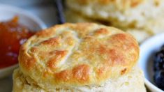 two biscuits are stacked on top of each other in front of some fruit and dipping sauces