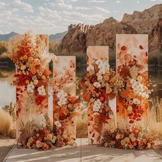 an outdoor ceremony setup with flowers and foliage on the side, along with three tall banners