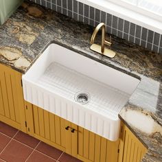 a white sink sitting on top of a counter next to a yellow cabinet under a faucet