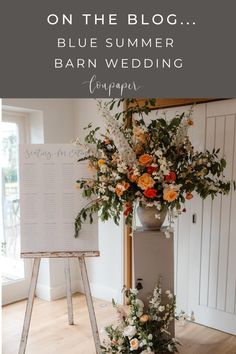 a bouquet of flowers sitting on top of a table next to a sign that says, on the blog blue summer barn wedding