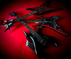 three guitars sitting on top of a red surface