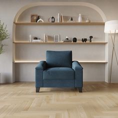 a blue chair sitting on top of a hard wood floor next to a shelf filled with vases