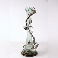 a glass vase with flowers and vines in it