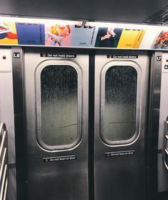 two double doors on the side of a subway car with advertisements above them and below it