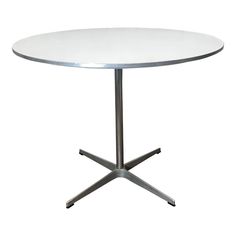 a round white table with metal legs and an aluminum base, on a white background