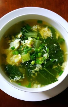 a white bowl filled with soup on top of a wooden table