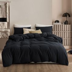 a bed with black sheets and pillows in a room