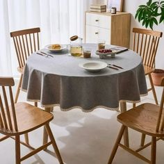 the table is set with two chairs and plates of food on it, along with a potted plant