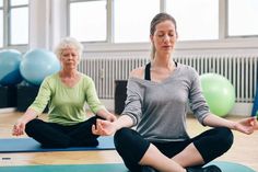 two women are doing yoga in front of blue and green exercise balls on the floor