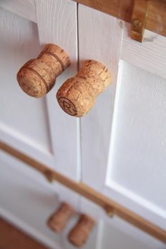 two wine corks hanging from the side of a door