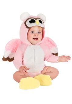 a baby in a pink owl costume sitting on the floor with its hands out and eyes closed