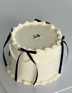 a white cake with black ribbon around it