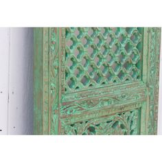 an old green door with intricate carvings on it