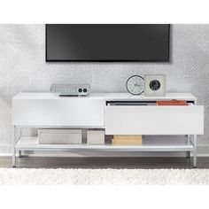 an entertainment center with a flat screen tv mounted on it's sideboard in front of a white wall