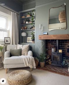 a living room filled with furniture and a fire place in front of a mirror on the wall