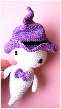 a crocheted stuffed animal wearing a purple hat